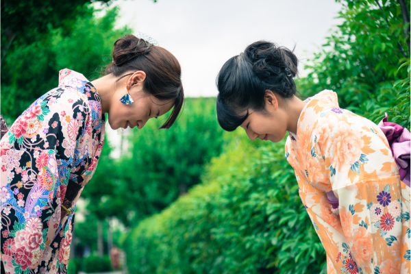 Japanese women in kimonos greeting one another